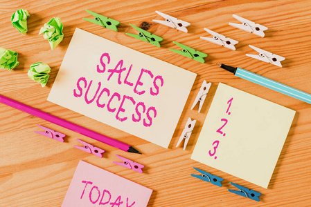 彩色衣夾放在木制地板中央的空矩形方形提醒紙條周圍。有凹槽和槽的木頭。辦公用品,鉛筆和鋼筆。